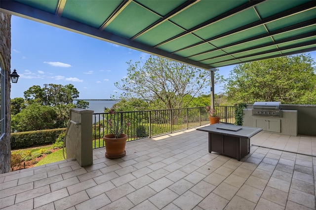view of patio featuring a water view, grilling area, and an outdoor kitchen