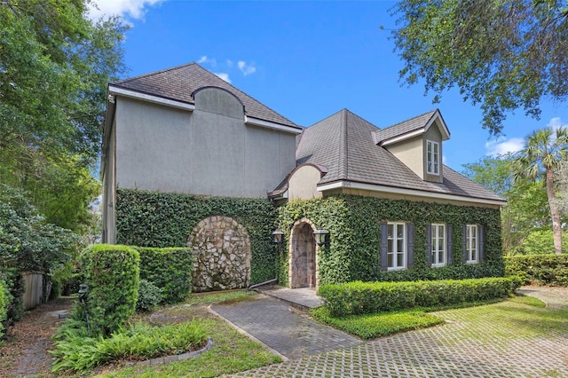 french provincial home with stucco siding