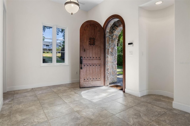 entryway featuring baseboards and arched walkways