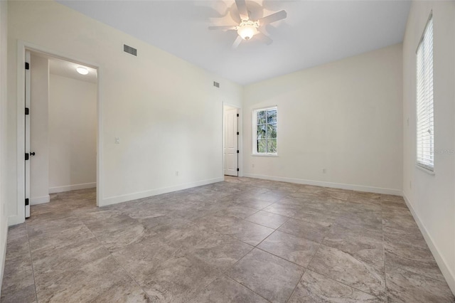 unfurnished room featuring a ceiling fan, baseboards, visible vents, and a healthy amount of sunlight