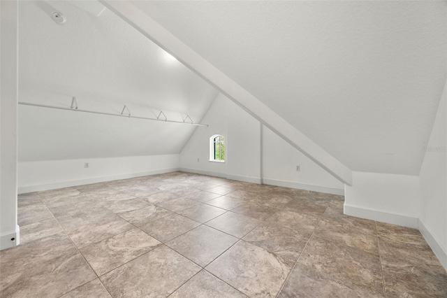 bonus room with baseboards and lofted ceiling