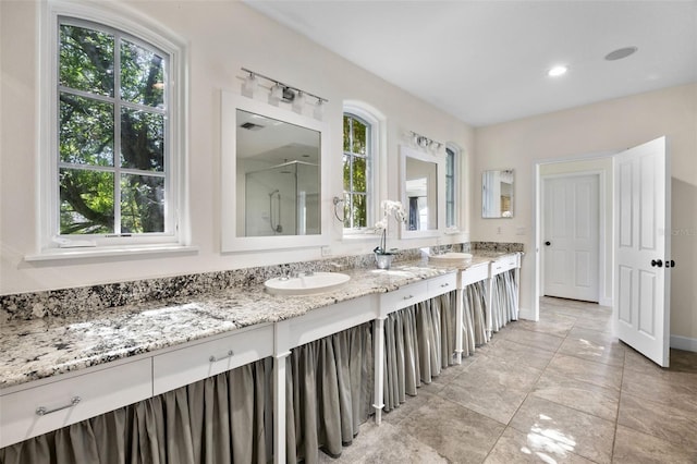 bathroom featuring double vanity, a sink, and a wealth of natural light