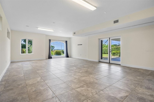 unfurnished room with french doors, baseboards, visible vents, and light tile patterned floors