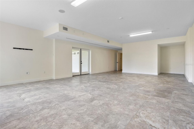 spare room featuring baseboards and visible vents