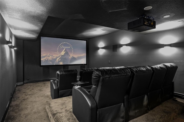 carpeted cinema room featuring baseboards and a textured ceiling
