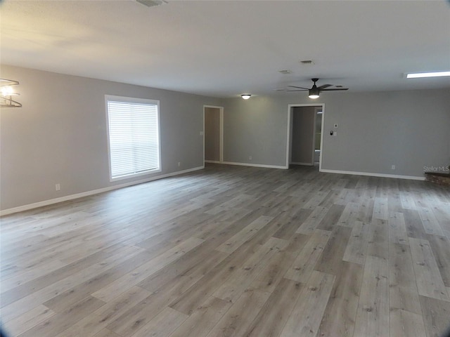 unfurnished room featuring baseboards, ceiling fan, and wood finished floors