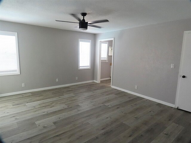 unfurnished room featuring baseboards, ceiling fan, and wood finished floors