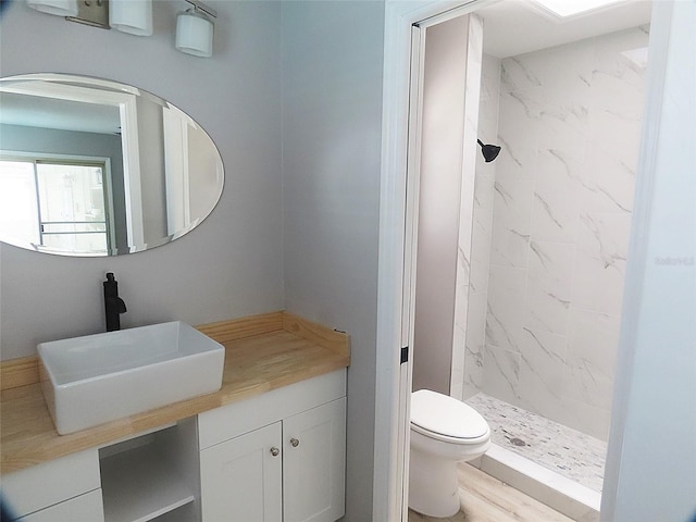 full bathroom with toilet, a marble finish shower, and vanity