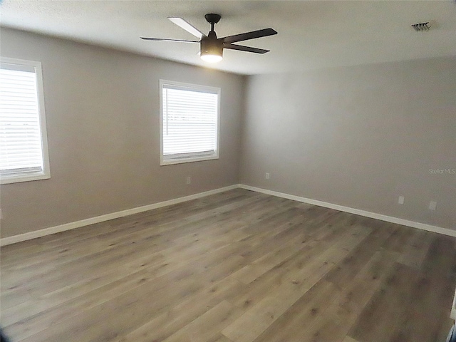 unfurnished room with ceiling fan, baseboards, and wood finished floors