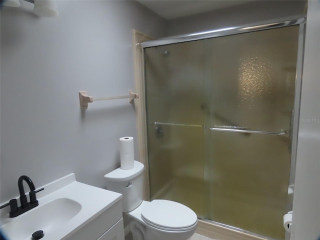 bathroom with a stall shower, vanity, and toilet