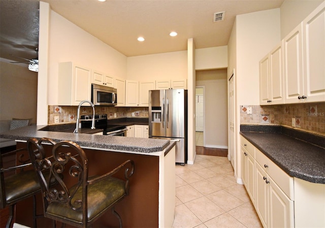 kitchen featuring stainless steel appliances, dark countertops, light tile patterned floors, backsplash, and recessed lighting