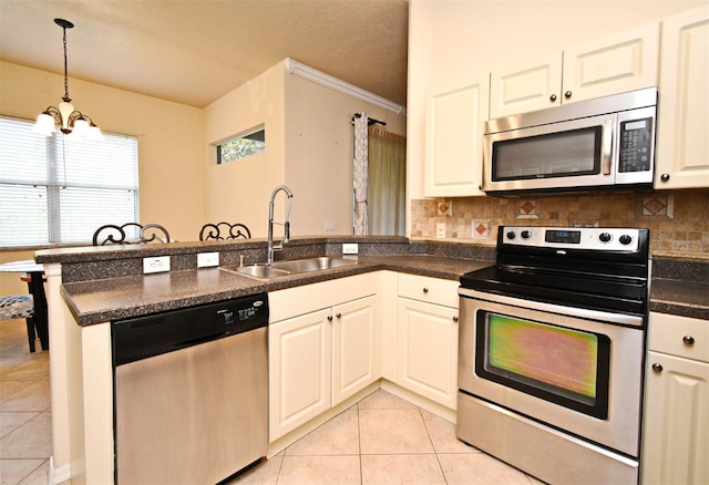 kitchen with stainless steel appliances, a sink, light tile patterned floors, a peninsula, and ornamental molding