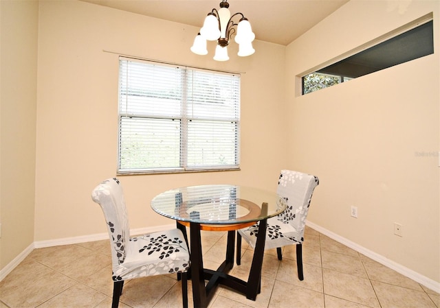 dining area with a chandelier, light tile patterned flooring, and baseboards