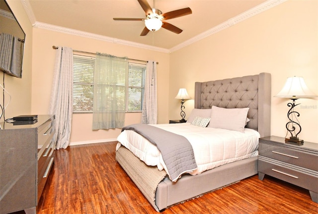 bedroom featuring wood finished floors, crown molding, a ceiling fan, and baseboards
