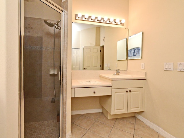 full bath featuring a shower stall, tile patterned flooring, vanity, and baseboards