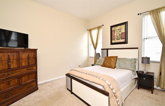 bedroom featuring light carpet and baseboards