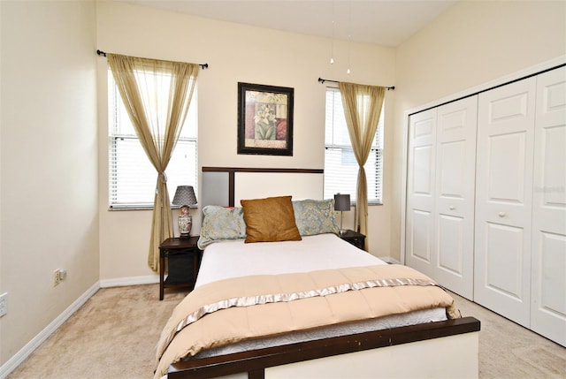 bedroom with light carpet, a closet, and multiple windows