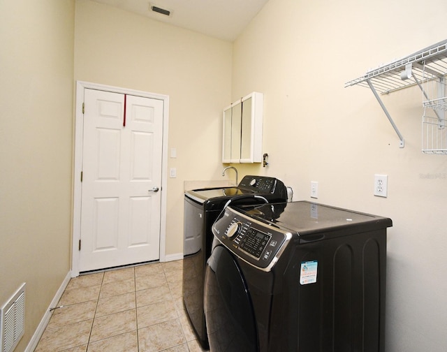 laundry room with washing machine and clothes dryer, cabinet space, baseboards, and light tile patterned flooring