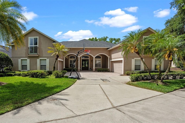 5108 Sailwind Cir, Orlando, FL 32810 - mediterranean / spanish home featuring driveway, an attached garage, french doors, stucco siding, and a front lawn
