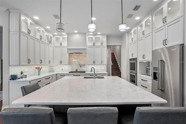 5108 Sailwind Cir, Orlando, FL 32810 - kitchen featuring appliances with stainless steel finishes, a sink, an island with sink, white cabinets, and recessed lighting