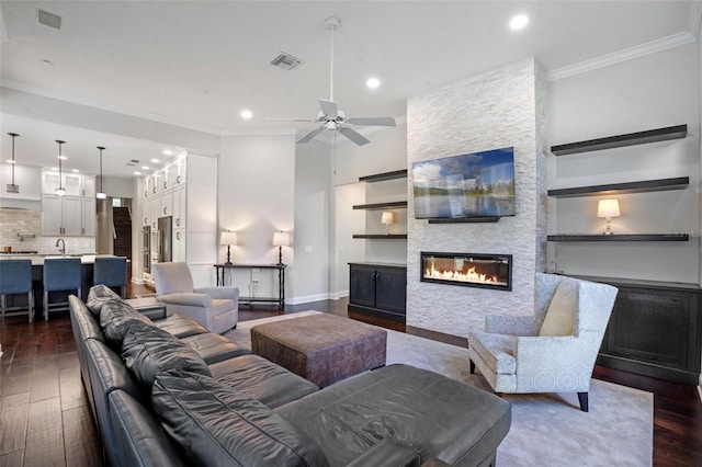 5108 Sailwind Cir, Orlando, FL 32810 - living room featuring a fireplace, recessed lighting, crown molding, dark wood-style flooring, and a ceiling fan