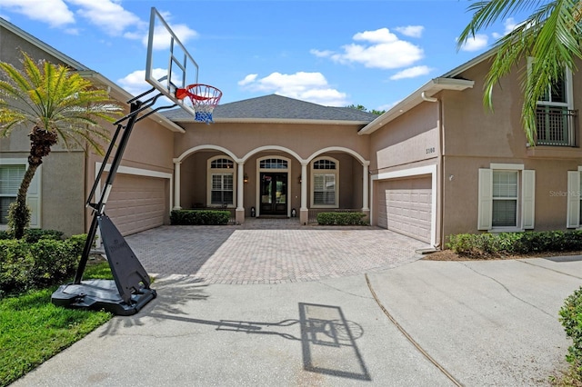 5108 Sailwind Cir, Orlando, FL 32810 - mediterranean / spanish-style home with an attached garage, decorative driveway, stucco siding, and french doors