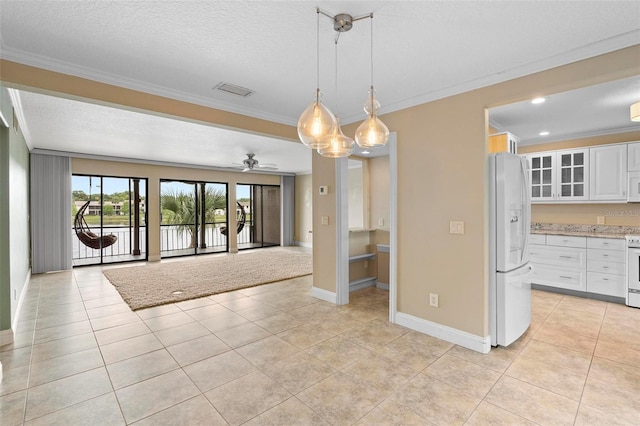 interior space with ornamental molding, light tile patterned floors, baseboards, and ceiling fan