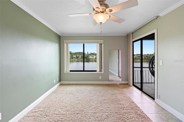 empty room featuring a water view, a healthy amount of sunlight, crown molding, and a ceiling fan