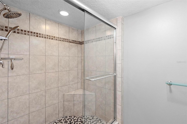 full bathroom with a textured ceiling, a stall shower, and recessed lighting