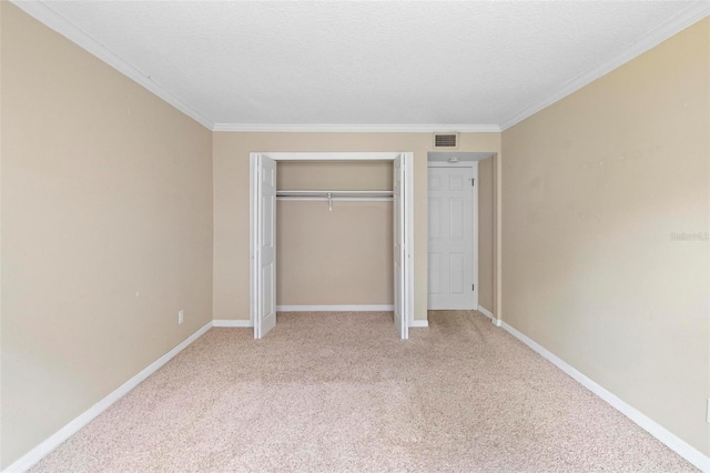 unfurnished bedroom featuring a closet, visible vents, baseboards, light colored carpet, and ornamental molding