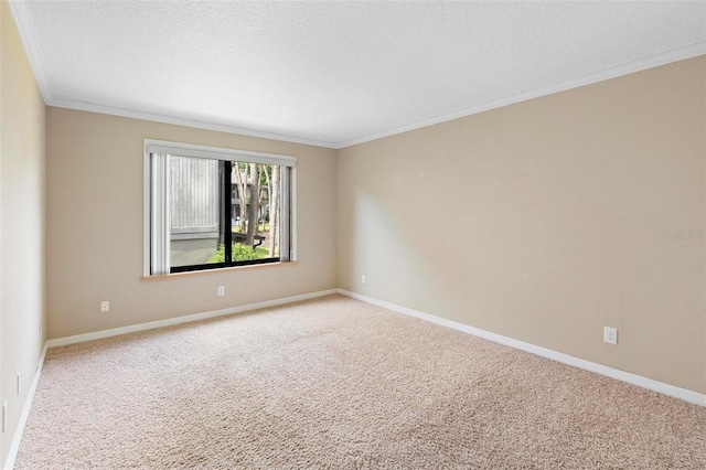 carpeted spare room featuring baseboards, ornamental molding, and a textured ceiling