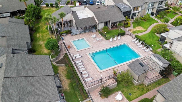 pool with fence, a patio, and a residential view