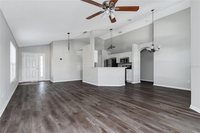 1175 Seasons Blvd, Kissimmee, FL 34746 - unfurnished living room with vaulted ceiling, baseboards, ceiling fan with notable chandelier, and dark wood-style floors