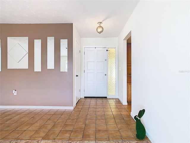foyer entrance featuring light tile patterned floors and baseboards