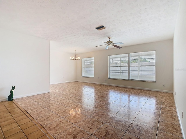 tiled empty room featuring a textured ceiling, visible vents, baseboards, and ceiling fan with notable chandelier