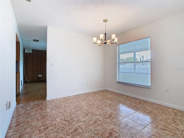 spare room featuring baseboards, an inviting chandelier, visible vents, and light tile patterned floors