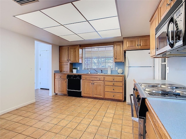 kitchen with freestanding refrigerator, black dishwasher, visible vents, a sink, and stainless steel electric stove