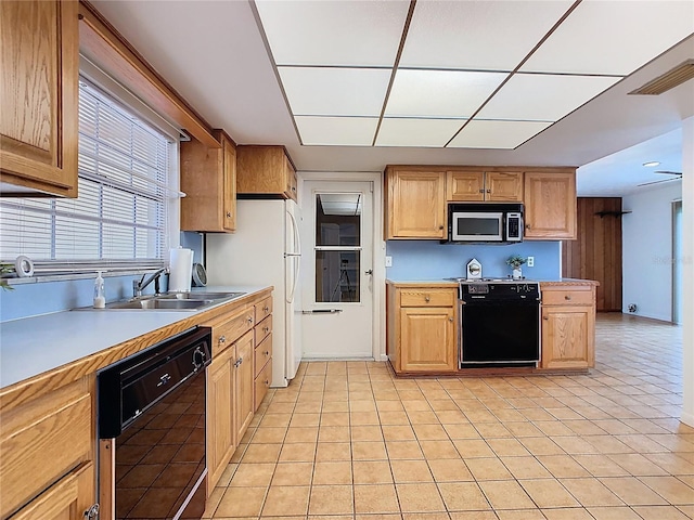 kitchen with a sink, black appliances, visible vents, light countertops, and light tile patterned floors