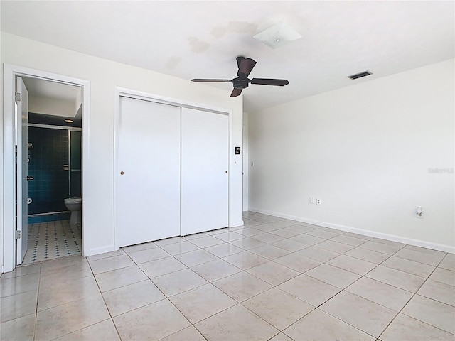 unfurnished bedroom with a closet, ensuite bath, visible vents, and light tile patterned flooring