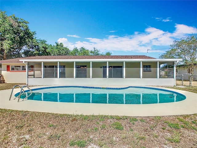 view of swimming pool featuring a sunroom, a patio, and a fenced in pool