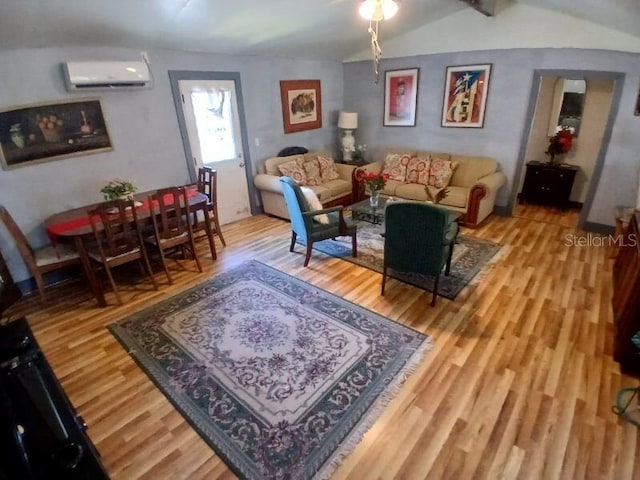 living area featuring lofted ceiling, wood finished floors, and an AC wall unit