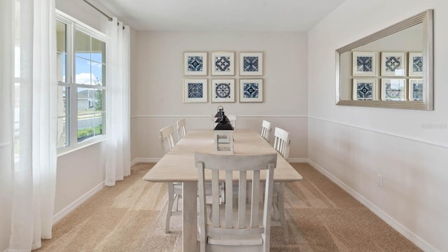 carpeted dining room featuring baseboards