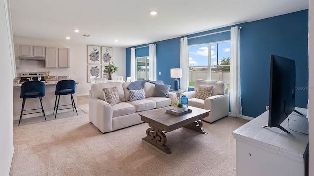 living room with light carpet, visible vents, and recessed lighting