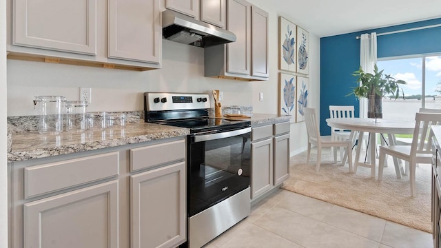 kitchen featuring light colored carpet, light stone countertops, electric stove, under cabinet range hood, and light tile patterned flooring