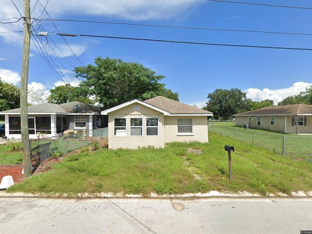 view of front of house with a sunroom and fence