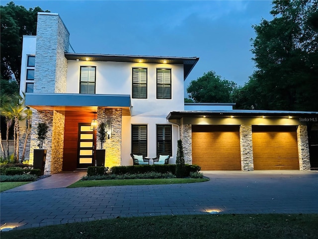 1831 Mizell Ave, Winter Park, FL 32789 - modern home featuring stone siding, stucco siding, a garage, and driveway