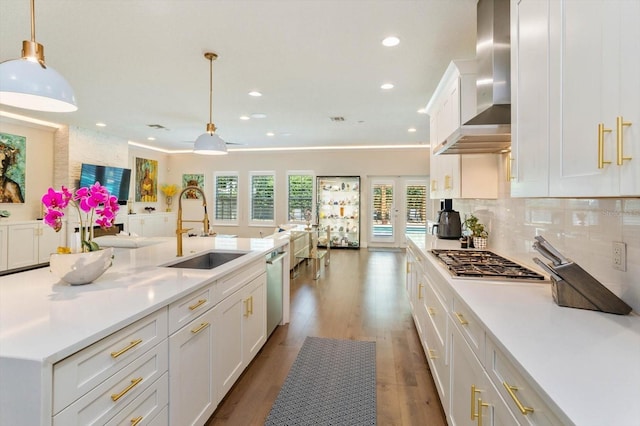 1831 Mizell Ave, Winter Park, FL 32789 - kitchen with a sink, stainless steel appliances, wall chimney exhaust hood, light countertops, and white cabinets