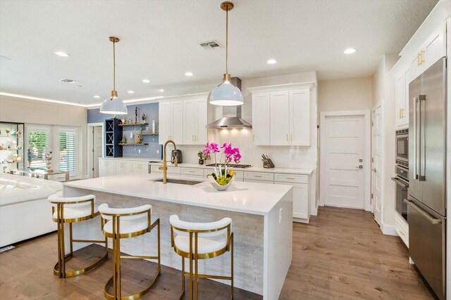 1831 Mizell Ave, Winter Park, FL 32789 - kitchen featuring a sink, appliances with stainless steel finishes, light countertops, white cabinets, and light wood finished floors