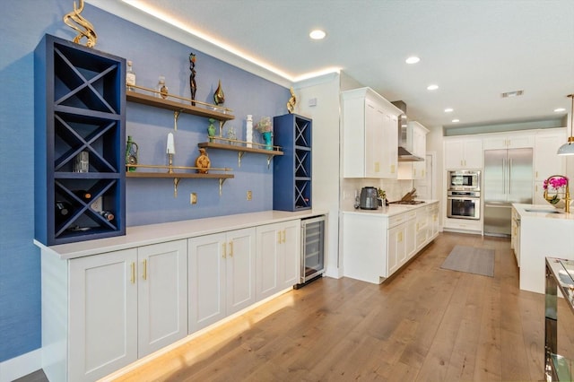 1831 Mizell Ave, Winter Park, FL 32789 - kitchen featuring wine cooler, appliances with stainless steel finishes, a sink, white cabinets, and tasteful backsplash
