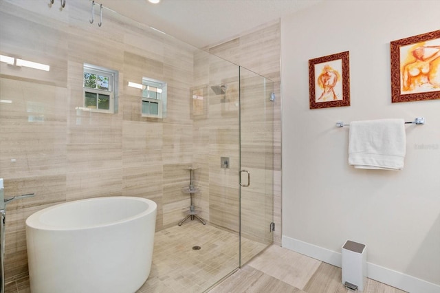 1831 Mizell Ave, Winter Park, FL 32789 - full bath featuring a shower stall, a soaking tub, and baseboards